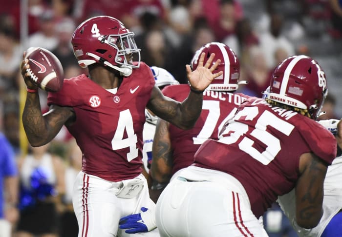 Sep 2, 2023; Tuscaloosa, Alabama, USA; Alabama Crimson Tide quarterback Jalen Milroe (4) throws behind a block by offensive lineman JC Latham (65) against the Middle Tennessee Blue Raiders during the first half at Bryant-Denny Stadium.